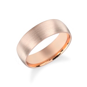 May include: A brushed rose gold wedding band with a polished edge.