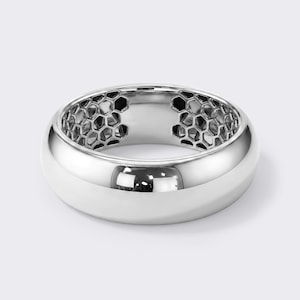May include: A polished silver-toned ring with a smooth, rounded exterior surface. The interior of the band features a distinct, recessed honeycomb pattern consisting of interconnected hexagonal cutouts that create a textured, open-work design.
