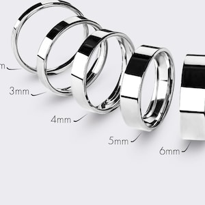 May include: A collection of silver rings in various widths, from 2mm to 6mm. The rings are displayed on a light background, showcasing their polished, reflective surfaces. The image highlights the different sizes available.