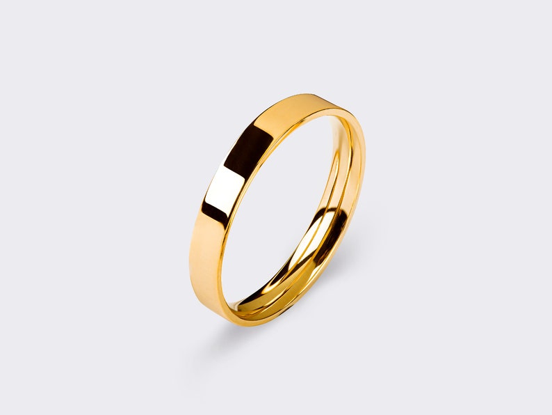 May include: A simple gold wedding band with a smooth, polished finish.