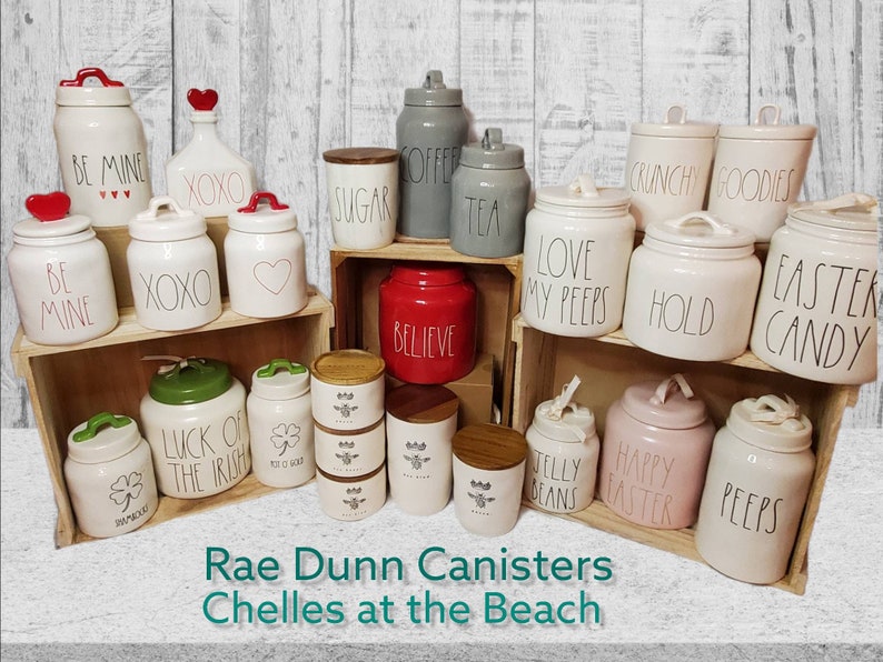 Puede incluir: Una colecci&oacute;n de botes de cer&aacute;mica Rae Dunn con varios dise&ntilde;os y lemas, incluyendo "Be Mine", "XOXO", "Sugar", "Coffer", "Tea", "Believe", "Love My Peeps", "Hold", "Easter Candy", "Luck of the Irish", "Jelly Beans", "Happy Easter", y "Peeps".