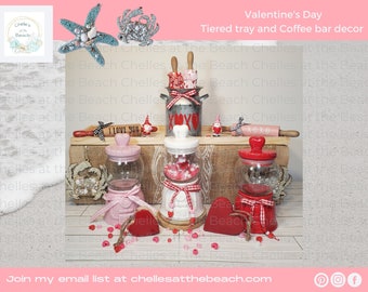 May include: Valentine's Day themed tiered tray decor with red and white gingham, a red heart, a white ceramic jar with the word "XOXO" on it, a pink jar with a heart on it, a red jar with a heart on it, a rolling pin with the words "I Love You" on it, and a small gnome figurine.