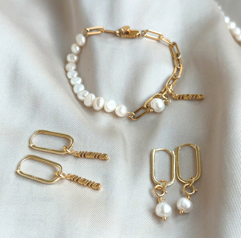 Pu&ograve; includere: Un set di gioielli in oro con un braccialetto di perle con una catena d'oro, un paio di orecchini a cerchio d'oro con un ciondolo di perla e un paio di orecchini d'oro con un ciondolo di perla e un ciondolo "mamma".