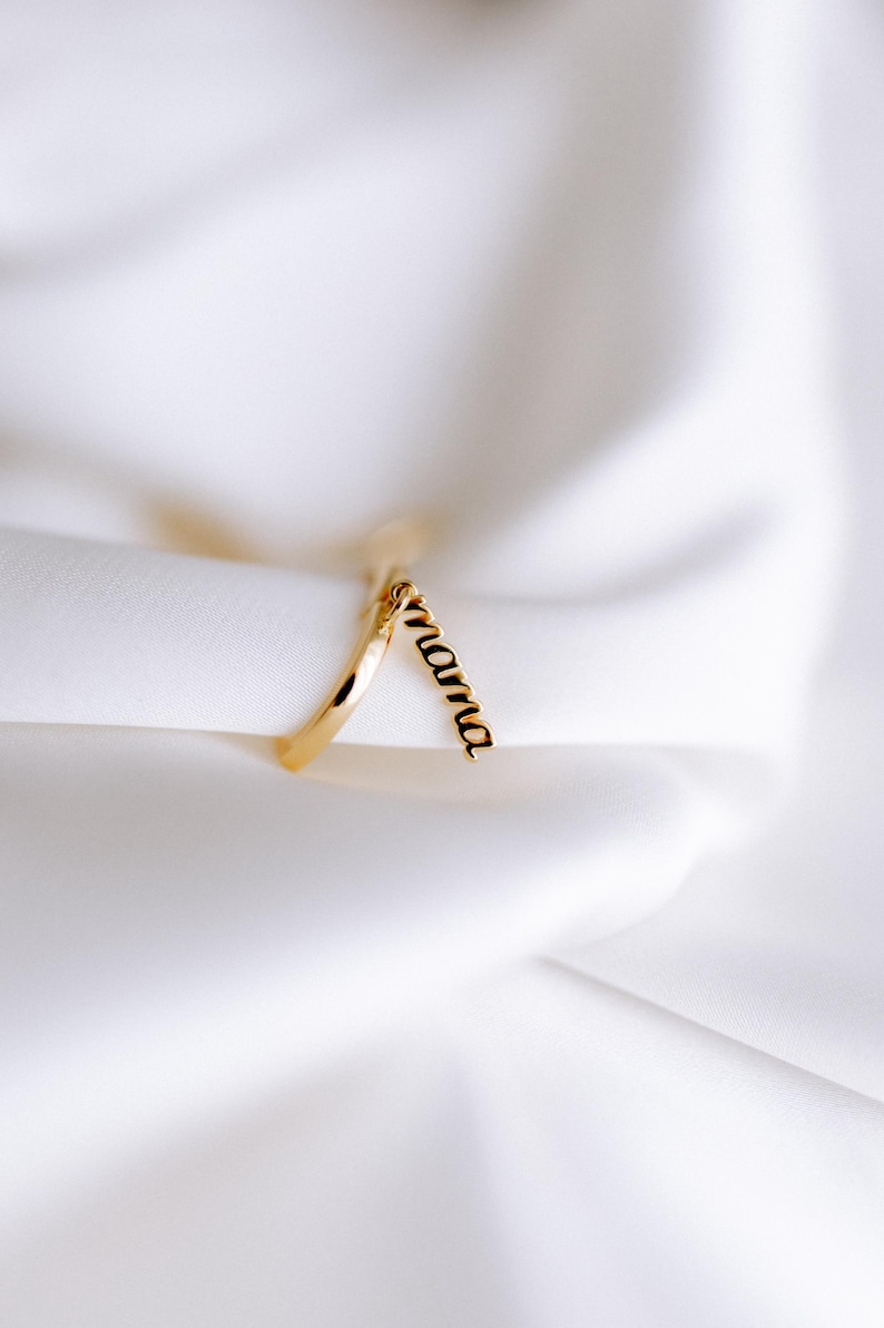 May include: A gold ring with a dangling charm that says "mama".