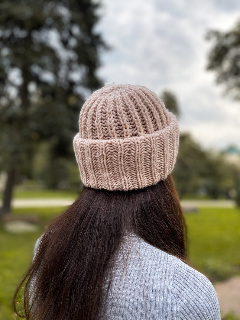 Puede incluir: Un gorro de punto rosa con textura de canal&eacute;. El gorro lo lleva puesto una persona con el pelo largo y casta&ntilde;o.
