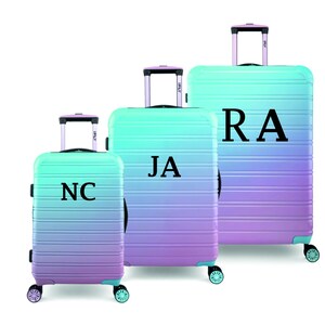 May include: Three ombre luggage sets with black initials "NC", "JA", and "RA" on the front.