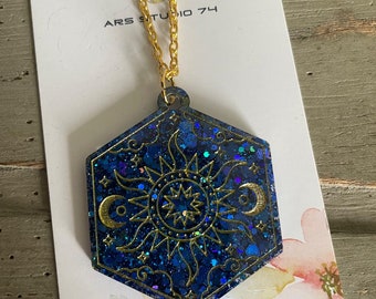 Handmade blue glitter resin moon and sun necklace on golden chain. Unique, bespoke, celestial jewellery