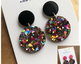 Brincos de resina circulares pendurados, pretos e com glitter, feitos à mão. Disponível em rosa-choque. Joias personalizadas, originais e festivas.
