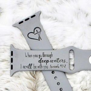 May include: Gray Apple Watch band with a heart and cross design and the text "When you go through deep waters, I will be with you (Isaiah 43:2)"