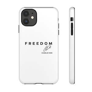 Könnte beinhalten: Weißes iPhone-Case mit schwarzem Rand. Auf der Vorderseite steht das Wort "FREEDOM" in fetter, schwarzer Schrift, darunter eine Unterschrift und der Name "CHARLIE KIRK". Das Bild zeigt die Vorder- und Seitenansicht.