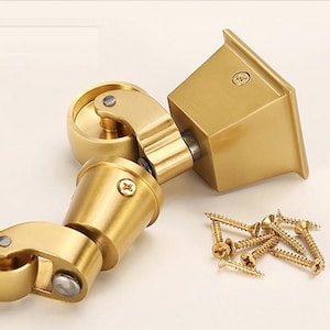 以下が含まれることがあります： 正方形のベースと両端に車輪が付いた金色の金属製の家具の脚。脚は家具に取り付けられて簡単に移動できるように設計されています。