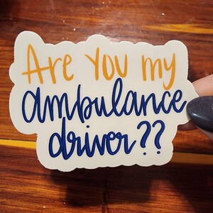 May include: A white sticker with the text "Are you my ambulance driver?" in blue and orange lettering.