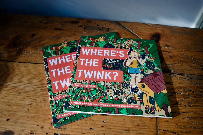 Może przedstawiać: Trzy egzemplarze książki dla dzieci zatytułowanej "Where's the Twink?" z zieloną, czerwoną i ż&oacute;łtą okładką przedstawiającą rysunek animowany chłopca z plecakiem i telefonem. Okładka książki zawiera tekst "Can you find Finn?" i "Created by Dan and Louis, with illustrations by Camille Ferrari!"