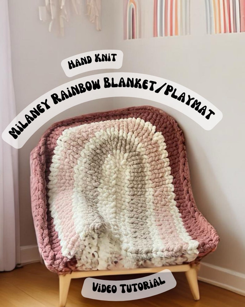 May include: A hand-knitted rainbow blanket or playmat in shades of pink, white, and brown. The blanket is draped over a wooden chair with the text "MILANEY RAINBOW BLANKET/PLAYMAT" and "HAND KNIT" above it. The text "VIDEO TUTORIAL" is below the blanket.