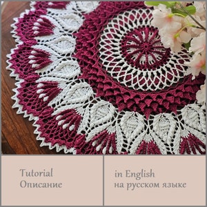 Könnte beinhalten: Eine runde Häkeldeckchen in Weiß und Burgunderrot mit einem floralen Muster. Die Deckchen ist rund und hat ein zartes Spitzenmuster. Die Deckchen liegt auf einer Holzoberfläche.