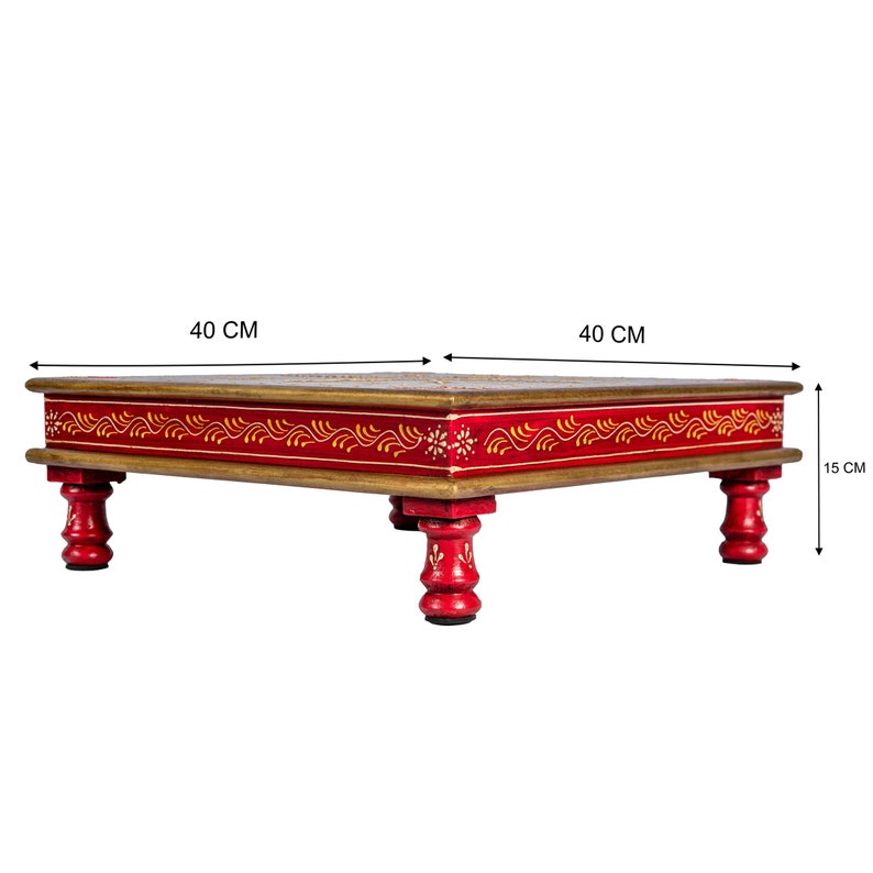 May include: A red wooden table with hand-painted floral designs and gold accents. The table is 40 inches wide and 15 inches tall.