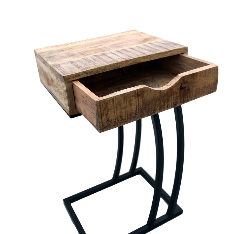 May include: A wooden side table with a drawer, featuring a natural wood finish and a black metal base. The drawer is partially open, revealing the interior. The table's design is modern and functional, suitable for a living room or bedroom.