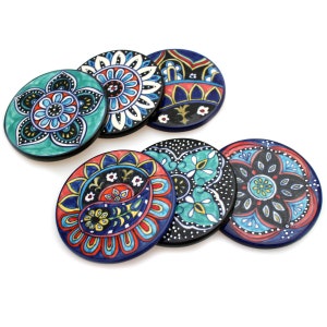 Puede incluir: Conjunto de seis posavasos de cerámica coloridos con intrincados diseños geométricos y florales. Los posavasos presentan una variedad de colores, incluyendo azul, verde, rojo y blanco.