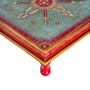 May include: A hand-painted wooden table with a blue and red top and gold trim. The table has four red legs with a turned design.