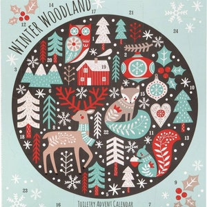 Könnte beinhalten: Ein türkisfarbener und schwarzer Adventskalender mit Winterwald-Motiv. Das kreisförmige Design zeigt Illustrationen einer Eule, eines Fuchses, eines Hirsches, Bäumen und Schneeflocken. Der Text "Winter Woodland" und "Toiletry Advent Calendar" sind abgebildet.