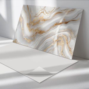 May include: A white and gold marble-patterned decorative wall panel with a subtle shimmer. The panel is made of a smooth, hard material and has a modern, abstract design.