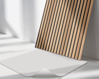 May include: A square wall panel featuring a repeating pattern of vertical light brown wood slats separated by thin black grooves. The panel has a white adhesive backing layer partially peeled away at the bottom corner to reveal the sticky surface.