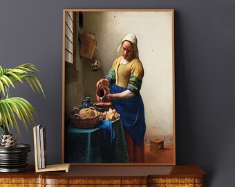Può includere: Stampa incorniciata di un dipinto classico raffigurante una donna che versa liquido da una brocca. Indossa un top giallo, una gonna blu e un copricapo bianco. Un tavolo con pane e un cesto è in primo piano.