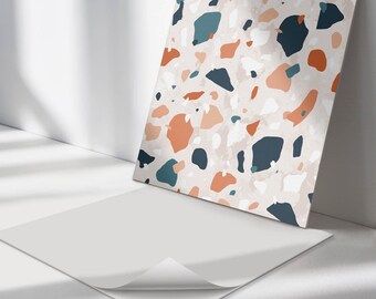 May include: A square adhesive sheet featuring a terrazzo pattern with irregular shapes in shades of dark blue, burnt orange, light peach, and white against a pale beige background. The sheet has a partially peeled corner revealing a white backing.