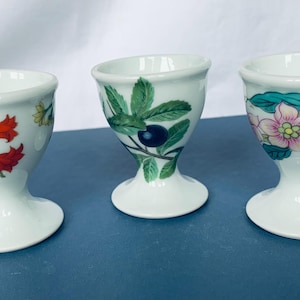 Set of three egg cups with different floral patterns from Porcelaine de Paris France. Mint condition.