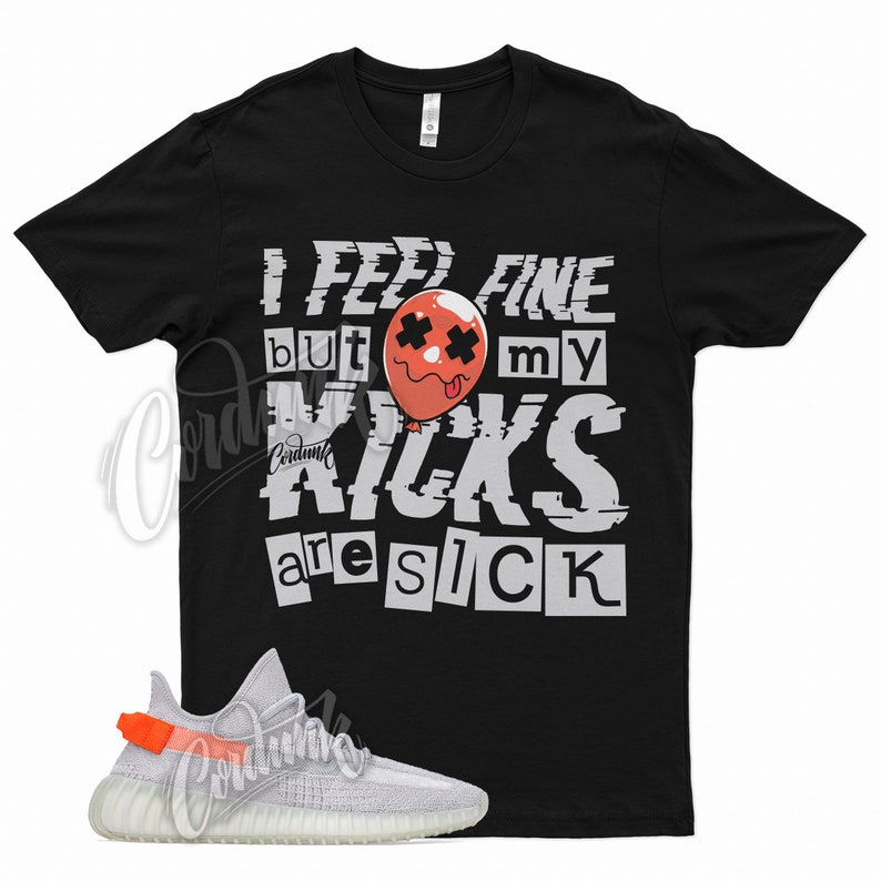 May include: Black t-shirt with the text "I feel fine but my kicks are sick" in a glitched font. A red balloon with a face is in the middle of the text. A pair of white and grey sneakers with orange accents are in the bottom left corner of the image.