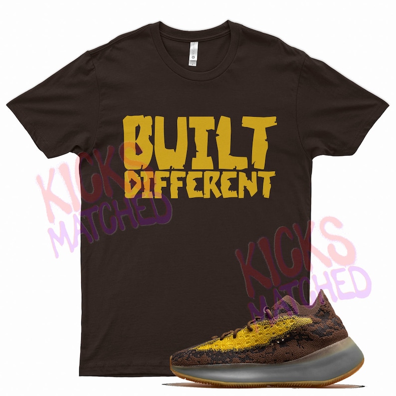 May include: A brown t-shirt with the text "BUILT DIFFERENT" in yellow. A pair of brown and yellow sneakers with a white sole.