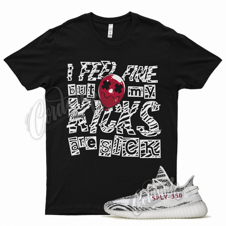May include: Black t-shirt with white zebra print and the text "I feel fine but my kicks are sick" with a red cartoon balloon with a face.  A pair of white and black zebra print sneakers with red text "SPLY-350" on the side.