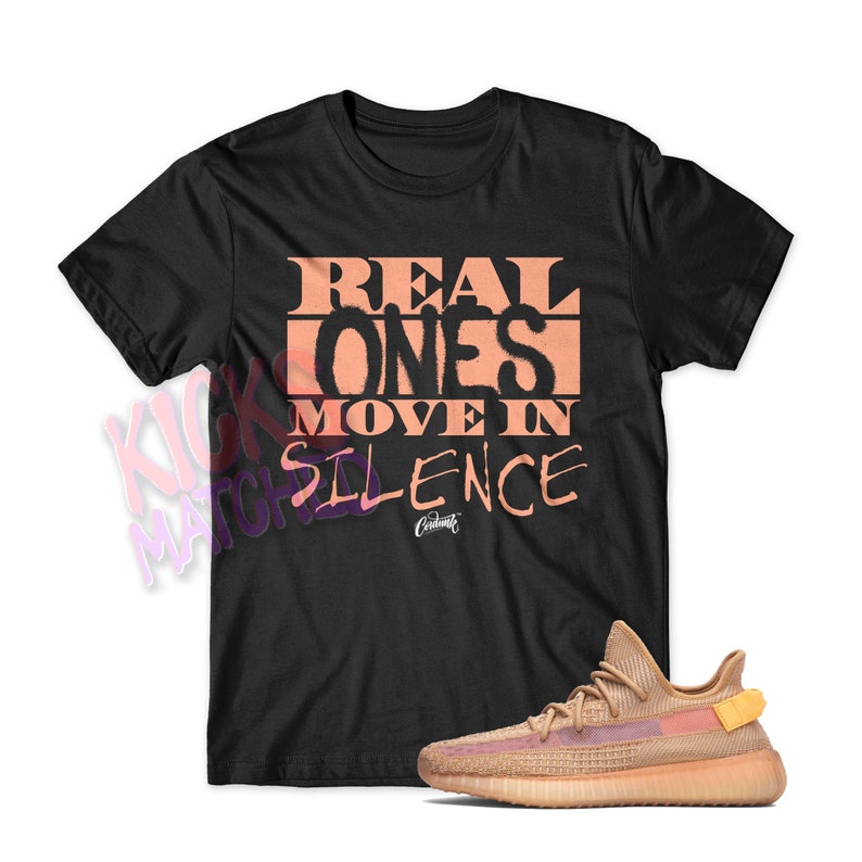 May include: A black t-shirt with the text "REAL ONES MOVE IN SILENCE" printed in peach on the front. A pair of peach-colored sneakers are also pictured.