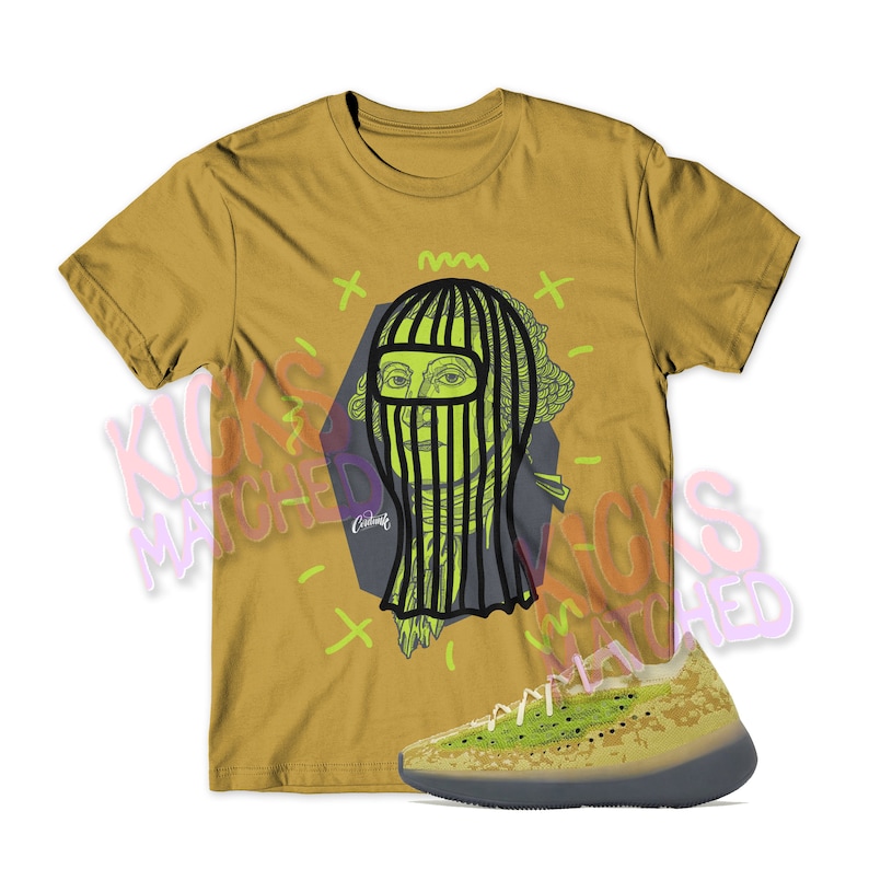 May include: A mustard yellow t-shirt with a graphic of a person wearing a black and green balaclava. The graphic is surrounded by yellow and green lines. A pair of green and black sneakers are also pictured.
