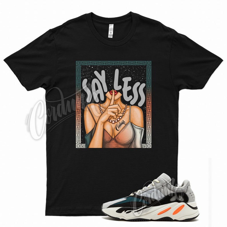 May include: Black t-shirt with a graphic of a woman with her finger to her lips and the text "Say Less". The woman is wearing a pearl necklace and a pink top. The graphic is surrounded by a teal and white border. A pair of white, black, and green sneakers are also pictured.