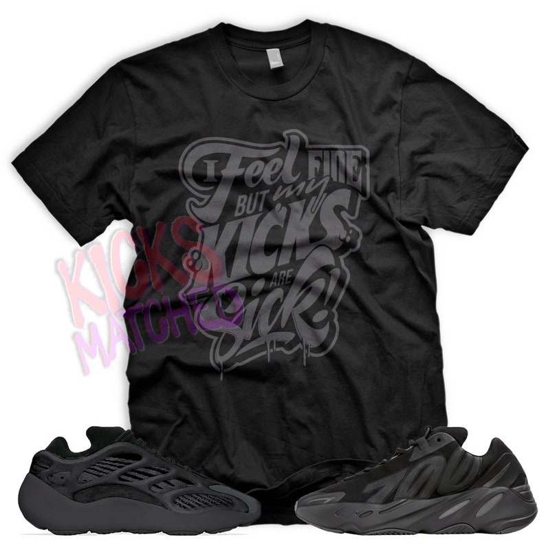 May include: Black t-shirt with the text "I feel fine but my kicks are sick!" printed on it. A pair of black Yeezy 700 sneakers are also pictured.