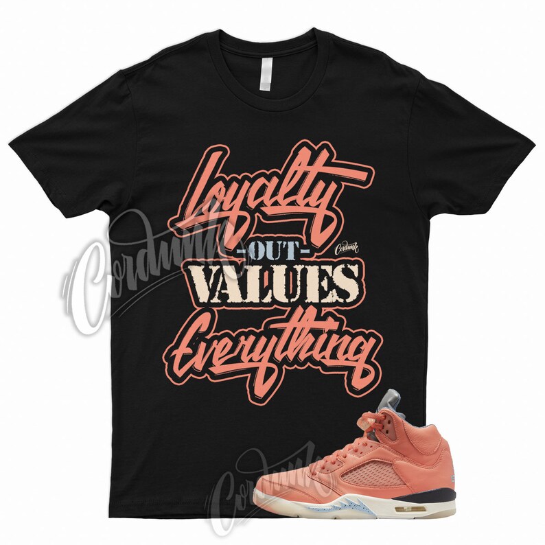 May include: Black t-shirt with the text "Loyalty Out Values Everything" in pink lettering. A pair of pink and white sneakers are shown below the shirt.