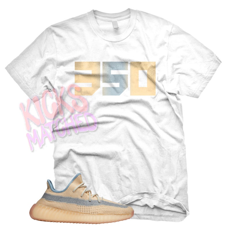 K&ouml;nnte beinhalten: Ein wei&szlig;es T-Shirt mit der Nummer "350" in einem verblassten, mehrschichtigen Stil in Blau und Gelb bedruckt. Darunter ist ein Paar hellbraune und blaue Sneaker mit wei&szlig;er Sohle zu sehen.