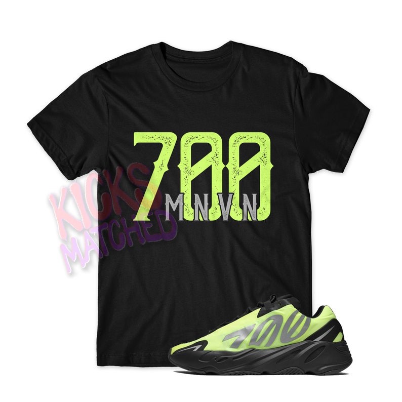 K&ouml;nnte beinhalten: Schwarzes T-Shirt mit einem neongr&uuml;nen "700 MNVN"-Druck und einem Paar schwarzer und neongr&uuml;ner Sneaker.