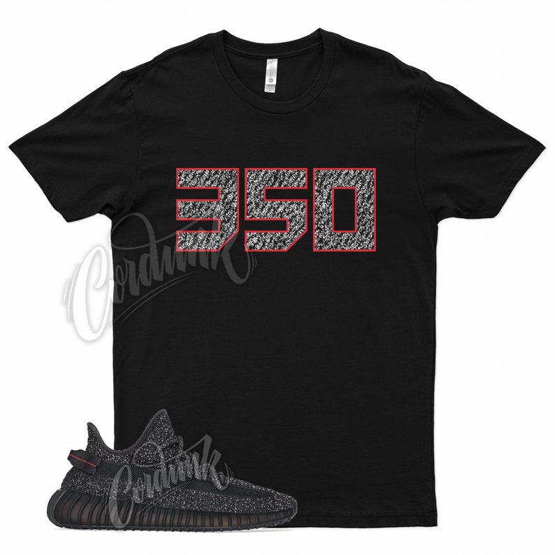 Peut inclure: T-shirt noir avec un contour rouge du nombre "350" dans un motif mouchet&eacute; gris. Une paire de baskets noires avec un motif mouchet&eacute; se trouve dans le coin inf&eacute;rieur gauche de l'image.