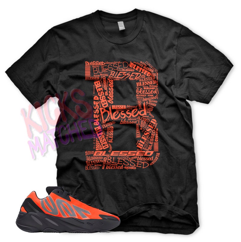 Puede incluir: Una camiseta negra con un gran gr&aacute;fico rojo de la palabra "Blessed" repetida en diferentes tama&ntilde;os y orientaciones. Un par de zapatillas negras y naranjas con suela gruesa.