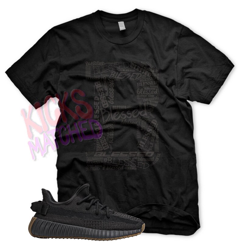 May include: Black t-shirt featuring a graphic design of the word "blessed" repeated in various sizes and orientations. The shirt is paired with black and brown trainers.