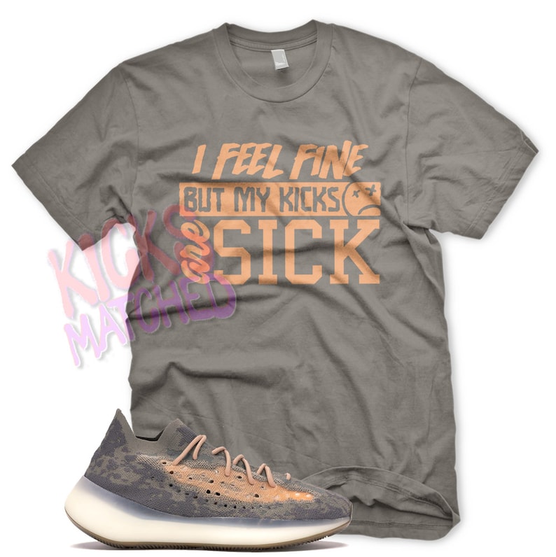 May include: A gray t-shirt with the text "I feel fine but my kicks are sick" in orange. A pair of gray and orange sneakers with a white sole.