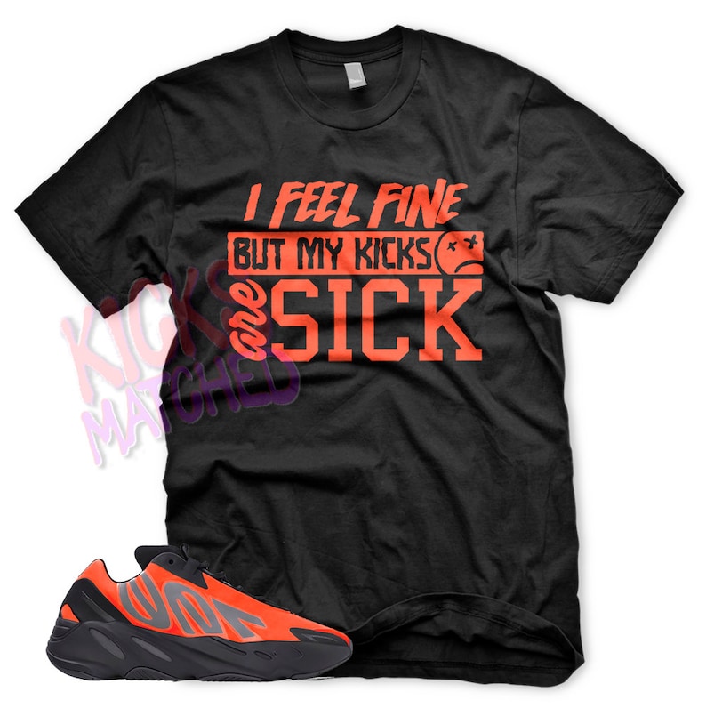 May include: Black t-shirt with orange text that reads "I feel fine but my kicks are sick" with a sad face emoji. A pair of orange and black sneakers are shown below the t-shirt.