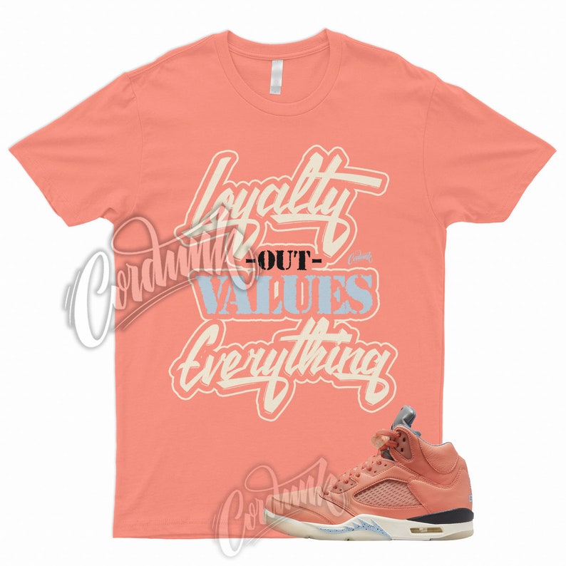 May include: A coral pink t-shirt with the text "Loyalty Out Values Everything" in a white and light blue font. A pair of coral pink and light blue sneakers are shown below the t-shirt.