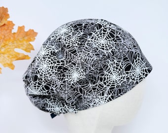 Gorro quirúrgico estilo telaraña de Halloween para mujer, con forro de satén, de Paradise Caps. Brilla en la oscuridad.
