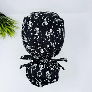 Glow Halloween Ponytail scrub cap for women. Dancing Skeletons Surgical hat with satin lined option by Paradise Caps.