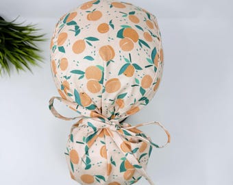 Ponytail Scrub Cap for women by ParadiseCaps. Peach satin lined option surgical hat with ponytail.