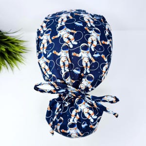 Astronaut Ponytail scrub cap by ParadiseCaps. Space Surgical cap for women with satin lined option.