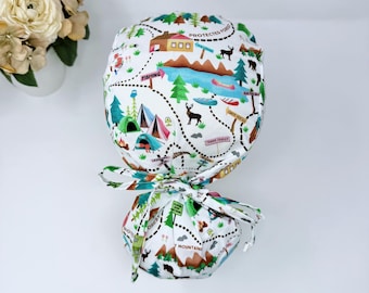 Gorro quirúrgico con coleta para mujer, ideal para acampar. Opción con forro de satén. Gorro quirúrgico con coleta de Paradise Caps. Estampado de paisaje de acampada.